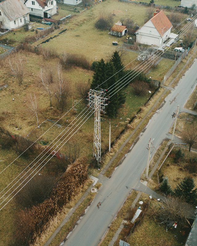 Linia energetyczna na słupie kratowym nad działkami – widok z góry